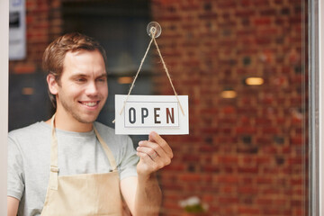 Open sign, startup and small business owner in coffee shop with pride and happiness to welcome...