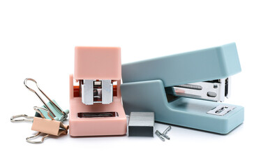 Office staplers, staples and paper clips on white background