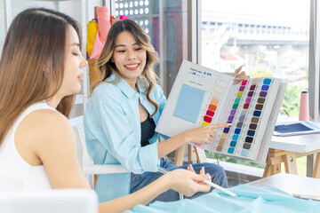 Two Asian women working together Small business, SME, tailoring designs for customers. Both of them acted as great designers.