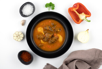 Hungarian beef goulash with paprika, garlic and potatoes on a white background. View from above. Hungarian cuisine.