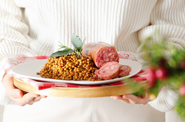 Festive Cristmas Italian Cotechino with lentils on white plate.