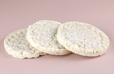 Rice crackers on a pink background, macro. Cereal crackers are high in fiber for healthy weight loss.