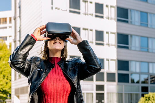 Young woman wearing virtual reality glasses outdoors
