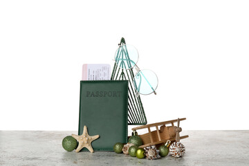 Passport with Christmas decor and wooden airplane on table against white background