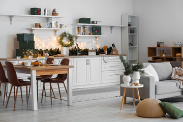 Interior of kitchen with Christmas wreath, dining table and sofa