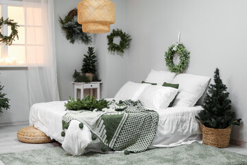 Interior of bedroom with Christmas mistletoe wreaths and fir trees