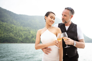 Happy Asian and caucasian white couple celebrating their marriage anniversary together on the...