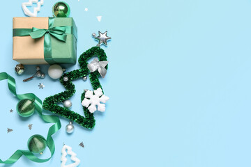 Composition with beautiful Christmas decorations and gift box on color background