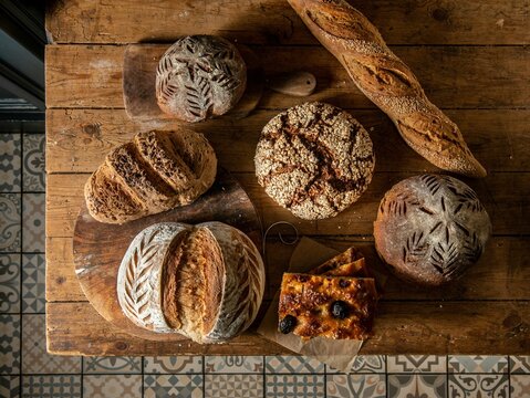 Naklejki Top view of different types of sourdough bread on a wooden board
