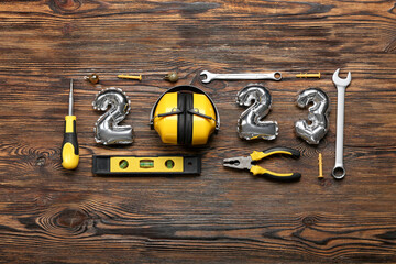 Figure 2023 made of balloons and builder's tools on wooden background