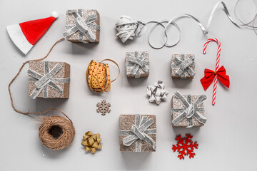 Composition with different Christmas gifts, decor and packing materials on grey background