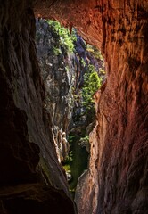 Views through the tinted cave to the narrow canyon