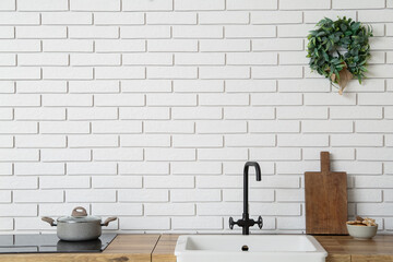 Christmas mistletoe wreath hanging on white brick wall in kitchen
