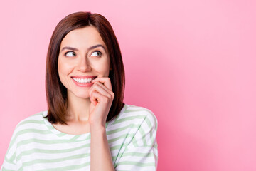 Close up photo of sweet cute lady bite fingernaills look empty space imagine date boyfriend isolated on pink color background