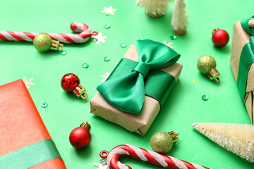 Gift boxes with Christmas decor on green background, closeup