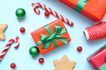 Gift box with Christmas decor and cookies on blue background