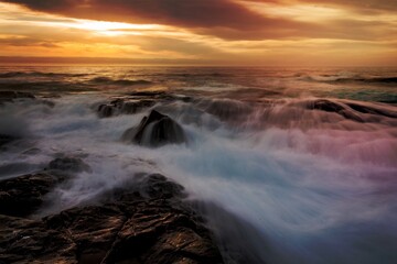 Fototapeta na wymiar Mystical light over the ocean with rocky ocean cascades