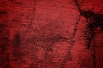 Obraz premium A textured background featuring deep red tones with a distressed, grunge appearance. The surface shows scratches and uneven patterns, creating a vintage feel.