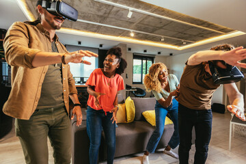 Happy friends having fun with VR in home interior