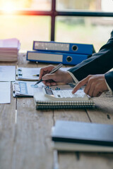 vertical view businessman hand holding a pen using a calculator Work with charts and analyze business strategies. financial statistics