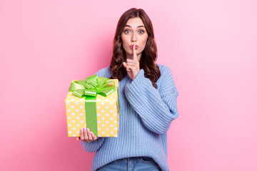 Portrait of charming person hold giftbox finger cover lips show shh gesture isolated on pink color background