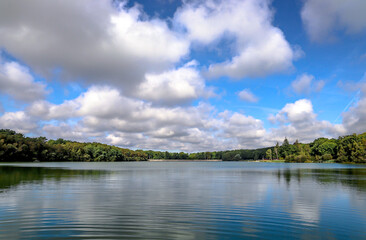 Obraz na płótnie Canvas paysage du lac grand bleu ciel nuages blancs la foret au fond