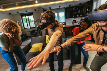 Happy friends having fun with VR in home interior