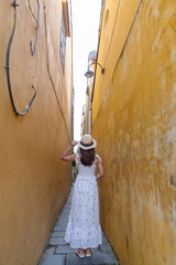 happy traveler sightseeing at Hoi An ancient town in central Vietnam, woman with dress and hat traveling. landmark and popular for tourist attractions. Vietnam and Southeast Asia travel concept