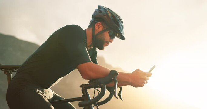 Phone, fitness and man on social media on a cycling break to recover on a bicycle cardio workout and exercise. Biker, sunset and healthy sports athlete enjoys online content on a social network app