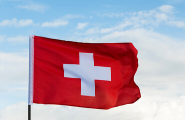 Swiss flag waving against sky