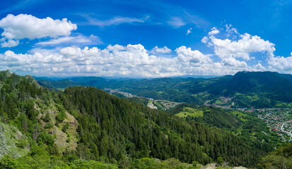 Fototapeta na wymiar Bulgarian town Smolyan with lake, vegetation and clouds. Rhodope Mountains. Panorama, top view