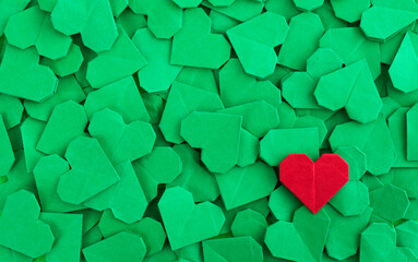 Red origami heart on green origami hearts