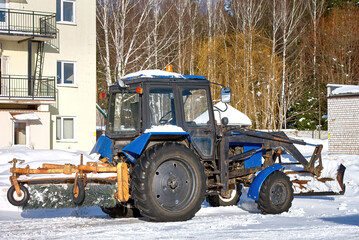 Tractor with sweeper brush and scraper parked at countryside. Snow removal vehicle parked. Tractor...