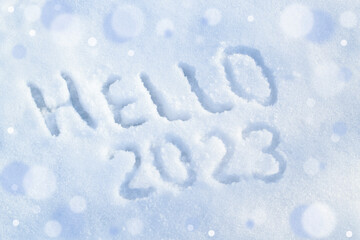 Hello 2023. Inscription on white snow surface. Happy new year concept. Top view, above.