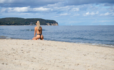 Beautiful woman on the beach, cloudy sky, sunny weather, nice bottom.