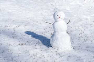 Snowman on white background. Green grass growing. First snow and outdoor games. New year and christmas time and mood.