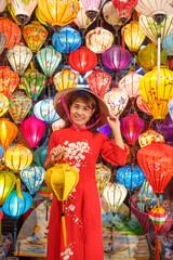 happy woman wearing Ao Dai Vietnamese dress with colorful lanterns, traveler sightseeing at Hoi An ancient town in central Vietnam.landmark for tourist attractions.Vietnam and Southeast travel concept