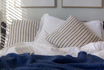 Cozy quilts and pillows on a bed in early morning light