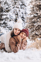 Obraz premium A couple stay on the snow in the Christmas forest