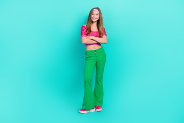 Fototapeta na wymiar Full length photo of sweet pretty schoolgirl wear pink crop top flared pants arms crossed isolated turquoise color background