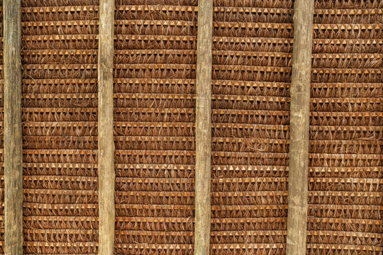 Structure of a roof with piassava, seen from the bottom up, showing its wooden structure and the braiding of straw.
