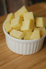close up of cube shape fresh cheese on in a bowl 