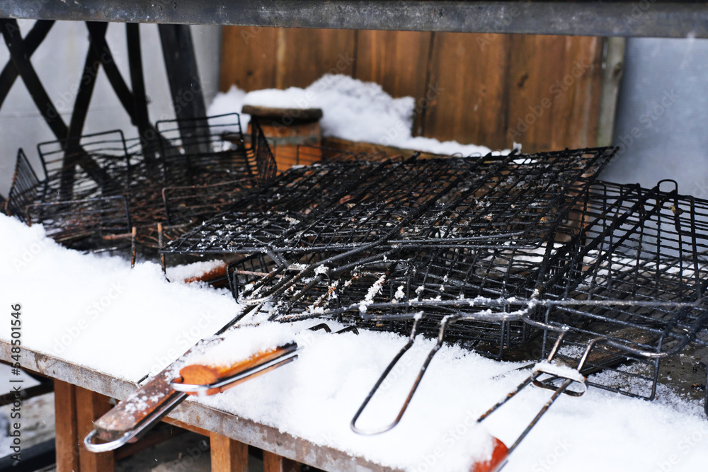 Wall mural metal grills for barbecue cooking lie on the street in winter weather