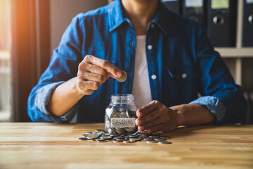 Woman puts a coin in a jar to save money for the future. after retirement and income, expenditure, savings and financial concepts