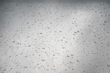 Raindrops on glass, on a gray background. Copy space. 