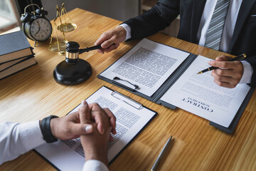 The business lawyer working about legal legislation in courtroom to help their customer, the Lawyer working with a client discussing contract paper