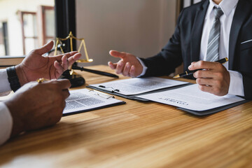 The lawyer working with a client discussing contract paper, a Business lawyer working about legal...