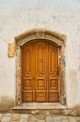 Fototapeta na wymiar An old wooden door in a white stone building in the old town of Bratislava. High quality photo