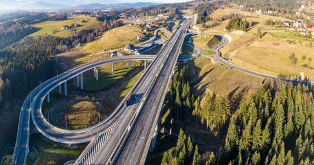 Poland. Zakopianka highway with newly opened tunnel in November 2022.  Multilevel spaghetti junction with traffic circles, viaducts, slip roads and traffic near Skomielna Biała. Aerial panorama - 548504924