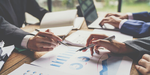 A business team consultant describes a marketing plan to set strategies for business owners using a calculator. business planning and business researching concepts.